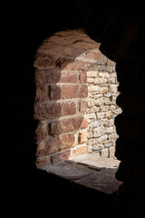 Close up of a brick arched window in a castle.