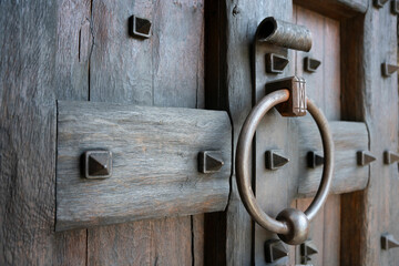 Close up of a decorative wooden mid-evil door and metal door knocker.