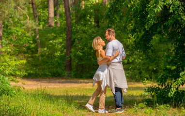 couple walking in the forest.young man and woman are walking relaxing in the forest together in full growth with free space for text.vacation family healthy lifestyle travel concept.