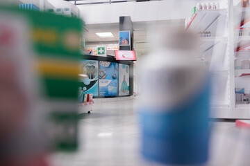 Selective focus of pharmacy counter desk filled with pharmaceutical products and computer, health space waiting for customers to come and buy pills. Drugstore shelves were stocked with drugs packages.