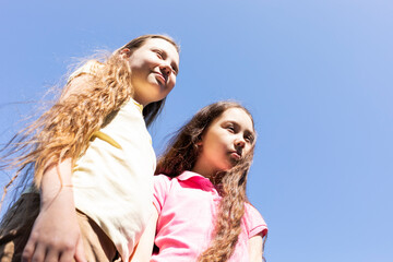 Portrait Smiling Two Pretty Sisters With Extra Long Hair, Blue Sky On Background, Sunny Day, Copy...
