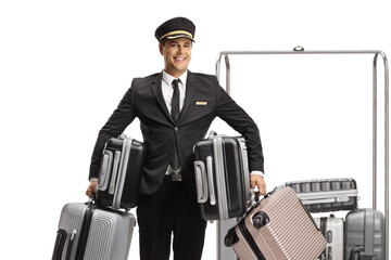 Bellboy holding many suitcases and standing in front of a luggage cart