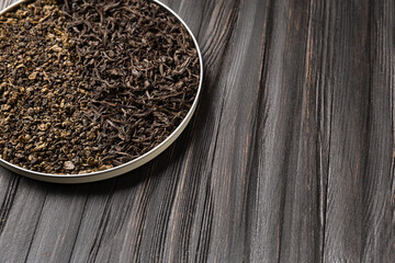 ?omposition of black and green tea on a wooden background.