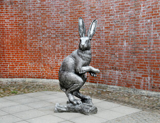 A statue of a hare on the background of a brick wall. Sights of Russia. Architecture of World Tourism. © Victor1153