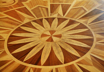 Parquet with circles and divergent rays of brown and yellow. Backgrounds, structure, technologies.
