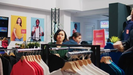 Anxious clients grab discounted clothes, rushing to catch big sales promotions on black friday. Obsessed people taking fashion items at outlet store, shopaholic buyers hunting for bargains.