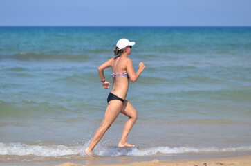 Fototapeta na wymiar Woman exercising by running on the beach