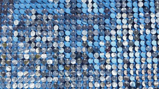 Silver mirror sequins sparkle and move in the wind, dynamic sparkling background