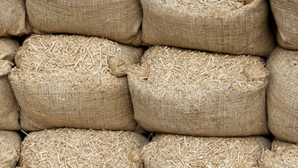 Fototapeta na wymiar Pile of sacks in a row ful with wooden pellets - generative ai