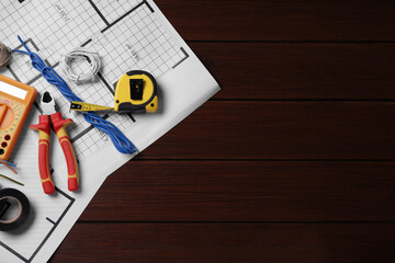 Different wires and electrician's tools on wooden table, top view. Space for text