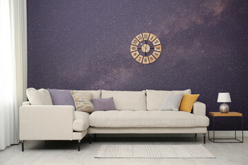 Amazing night starry sky as wallpaper pattern. Living room interior with comfortable sofa near wall