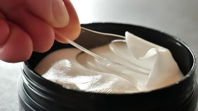 Eye patches.Eyelid Care. Hydrogel cosmetic eye patches in a black jar.Cosmetics for the skin of the eyelids. A transparent cosmetic spatula takes a hydrogel patch from a jar close-up. 4k footage