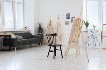 Studio with easels, chair and sofa. Artist`s workspace