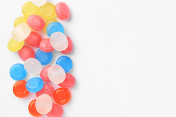 Many different colorful cough drops on white background, top view