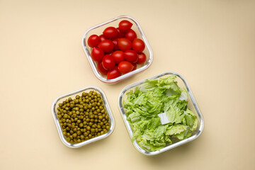 Glass containers with different fresh products on beige background, flat lay