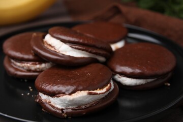 Tasty sweet choco pies on black plate, closeup