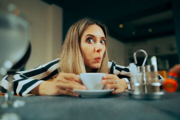 Funny Woman Having a Cup of Coffee in a Restaurant. Curious friend reacting to shocking news having...