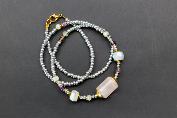 Colorful gemstone crystal beads necklace on black, unique handmade jewelry background, promotional photo for an online jewelry store