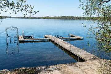 An empty wooden pier on Chautauqua Lake in Beemus Point, New York, USA on a sunny spring day