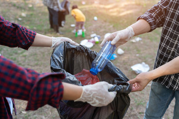 environmental protection Pollution and global warming problems Volunteers collect plastic bottles, rubbish into black bags, clean the park. The forest area is environmentally friendly and ecological.