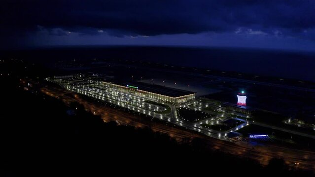 4K aerial footage of Rize Artvin Airport and tea glass-shaped airport traffic control tower with LED lights changing colors show. Drone footage of airport  against Black Sea and clouds in the dark.