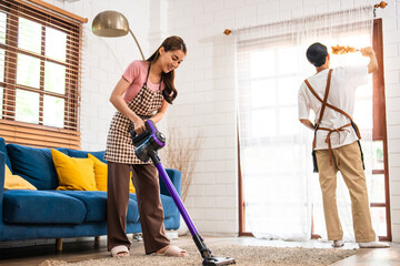 Asian attractive young man and woman cleaning house indoors together