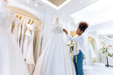 African American female designer designing bridal gown in wedding studio. 