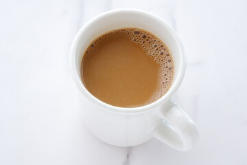 一日のスタートはミルクをたっぷり入れたコーヒーのマグカップ