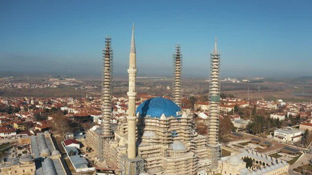 4K wide angle drone filming of Selimiye Mosque in Edirne in daylight against horizon. Scaffolds around buttresses, upper walls and minarets of Selimiye Mosque for renovation stock video.