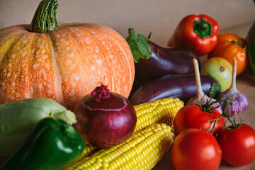 The concept of a happy Thanksgiving. Fresh harvest of vegetables pumpkin, corn, paprika, tomatoes, onions, eggplants. Organic background