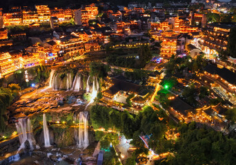Beautiful ancient town in China with waterfall and traditional houses at night