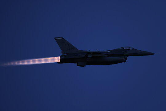 f16 fighter jet with afterburners at night. 