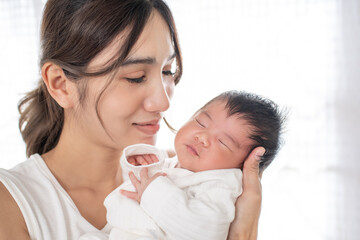 happy loving family. mother playing with her baby hugging in the bedroom , portrait of asian mother playing with newborn baby, health care family love together. asian girl lifestyle..