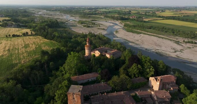 Village and castle of Rivalta with Trebbia River in rural landscape, Piacenza in Italy. Aerial tilt-down ascending