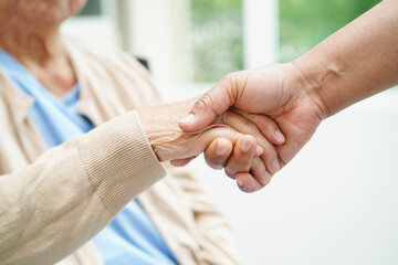 Caregiver holding hands Asian elderly woman patient, help and care in hospital.