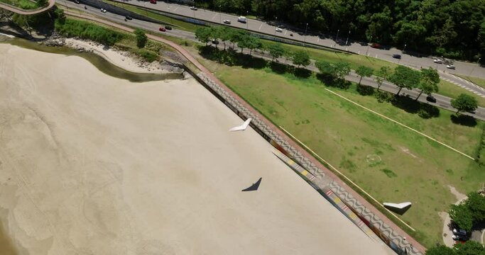 Top down aerial view of hang glider landing on the beach, Rio de Janeiro