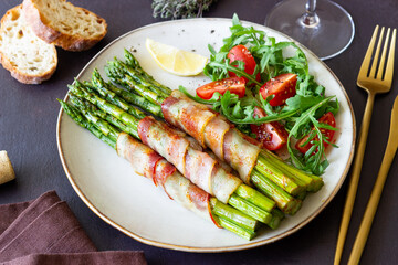 Asparagus baked with bacon and arugula and tomato salad. Healthy eating. Diet.