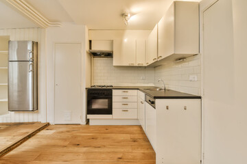a kitchen with white cabinets and black counter tops in the center of the photo is an oven, stove, sink, and dishwasher