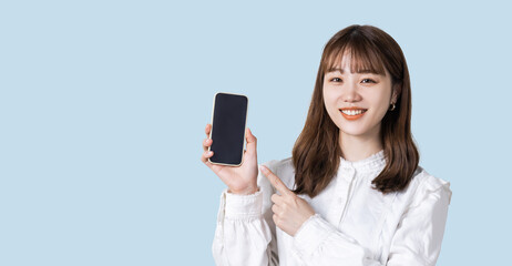 Fototapeta premium スマホを指差す笑顔のビジネスウーマン