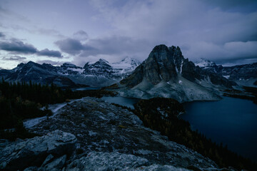 Fototapeta na wymiar vue sur la vallée avec un lac et de grandes montagnes avec le sommet derrière enneigé avant le lever du soleil