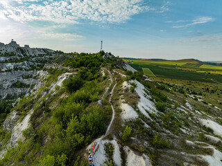 Fototapeta premium aerial view of a group of trail runners climbing on a trail in a limestone quarry in fetesti