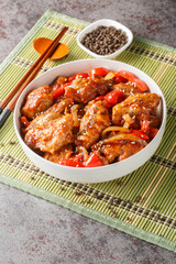 Chinese black pepper chicken with vegetables close-up in a plate on the table. Vertical