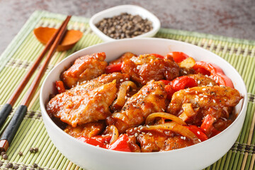 Stir fry pepper chicken with sweet peppers, onion, garlic and ginger closeup on the bowl on the table. Horizontal