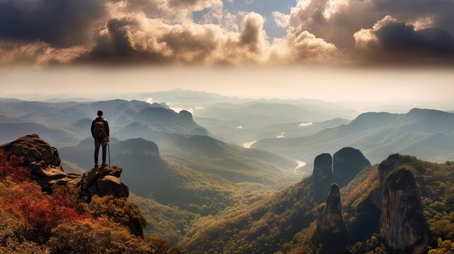 Hiker At The Summit Of A Mountain Overlooking A Stunning View