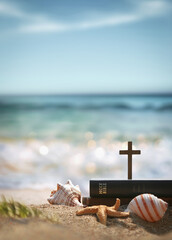 Bible book, cross of Jesus Christ, conch and starfish on sea waves and sandy beach, church summer retreat and summer bible school summer camp
