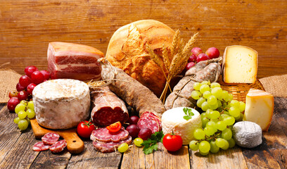 composition of cheese, salami,bread and grapes