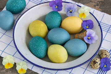 blau und gelb gefärbte Ostereier auf einem alten Emaille-Teller