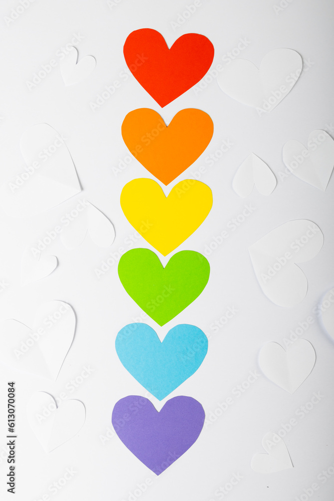 Poster overhead view of colorful heart shaped arranged in a row on white background, copy space