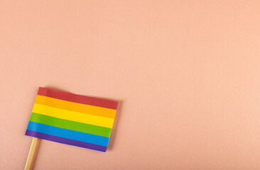 High angle view of rainbow flag with stick isolated against pink background, copy space