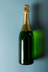 Overhead view of champagne bottle isolated against blue background, copy space
